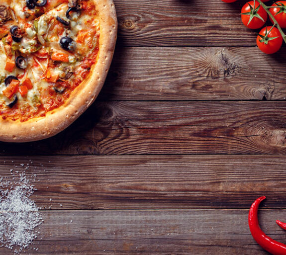 Italian pizza with tomatoes on a wooden table, top view.
